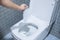 Woman hand throw paper towels in the toilet bowl. Cleaning, Lifestyle and personal hygiene concept