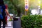 Woman hand throwing twisted empty water bottle in recycle bin. Gray plastic recycle bin. Backpacker discard bottle in trash bin.