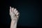 A woman hand tied with wire on dark background in low key.