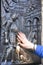 Woman hand touching relief with John of Nepomuk for good luck, Charles Bridge, Prague, Czech Republic