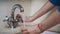 Woman hand turning knob on faucet and pouring water into glass