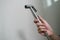 Woman hand using Chromium bidet shower sitting on toilet