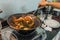 Woman hand using paddle while frying chilly crab in kitchen