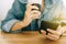 Woman hand using smartphone while drinking coffee with cafe shop colorful highlight shade to object beautiful backgroun