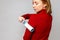 Woman hand using a sticky roller to clean fabrics - red woolen turtleneck from dust, hair, lint and fluff, front view, close up