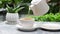 Woman hand, waiter pouring hot tea of teapot into cup in outdoors restaurant