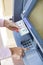 Woman hand withdrawing money from outdoor bank ATM