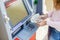 Woman hand withdrawing money from outdoor bank ATM