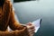 Woman hand writing down in small white memo notebook.