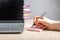 Woman hand writing reminders at sticky notes. Female sitting at desk with laptop and recording with pen key words and