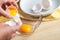 Woman hands breaking an egg to separate egg white and yolks, egg
