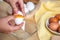 Woman hands breaking an egg to separate egg white and yolks, egg