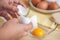 Woman hands breaking an egg to separate egg white and yolks, egg