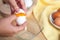 Woman hands breaking an egg to separate egg white and yolks, egg