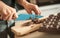 Woman hands chopping chocolate block for celebratory cake