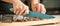 Woman hands chopping chocolate block for celebratory cake