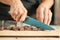 Woman hands chopping chocolate block for celebratory cake