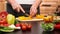 Woman hands chopping yellow pepper slices for a salad