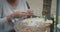 Woman hands closeup making Chinese food wonton outdoors with meat and dough