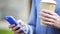 Woman hands with coffee cup and smartphone