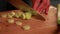 Woman hands cutting leek on wooden board close up