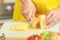 Woman hands cutting piece of cheese