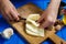 Woman hands cutting spicy homemade cheese on cutting board, serv