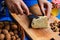 Woman hands cutting spicy homemade cheese on cutting board, serv