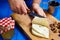 Woman hands cutting spicy homemade cheese on cutting board, serv