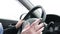 Woman hands drive a car, fingers lie on the steering wheel