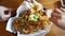 Woman hands eating Mexican nacho beef with cheese and cream