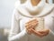 Woman hands with elegant french manicure nails design holding a cozy knitted mug. Winter and Christmas concept.