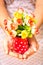 Woman hands giving away a vase of plastic flowers