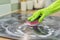 Woman hands in gloves cleans kitchen electric ceramic hob