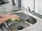 Woman with hands without gloves washes dishes with a dishwashing sponge with bubbles close-up, household chores, no