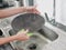 Woman with hands without gloves washes dishes with a dishwashing sponge with bubbles close-up, household chores, no