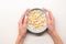 Woman hands hold bowl of breakfast flakes at white background. Healthy food, nutrition and lifestyle