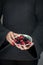 Woman hands holding a bowl of raspberries and blackberries, sensual studio shot