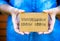 Woman hands holding cardboard card with words Declutter Your Life