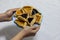 Woman hands holding colorful plate with apricot and blueberry hamantash Purim cookies