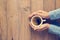 Woman hands holding cup of coffee on wooden background