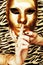 Woman hands holding golden carnival mask, rich luxury manicure and jewelry close up on zebra print