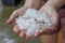 Woman hands holding hail stones in the garden after storm in the summer