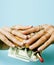 woman hands holding hamburger with money, jewelry, cosmetic