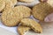 Woman hands holding homemade shortbread cookies made of oatmeal pile in plate on wooden table and sackcloth background. Concept