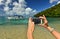 A woman hands holding mobile take photo of paradise beach