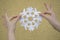 WOMAN HANDS HOLDING PAPER SNOWFLAKE CUT AS PEOPLE IN CIRCLE