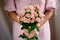 Woman hands holding pink roses bouquet with pink dress. natural light. concept of spring season. soft light. blooming pink roses
