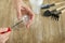 Woman hands holding plastic cup with made drainage holes on bottom using awl on the wooden background