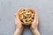 Woman hands holding a wooden bowl with close peanuts. Healthy food and snack. Vegetarian snacks of different nuts